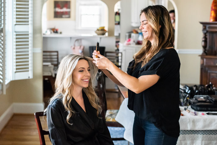 Brielle Brenner, Hair and Makeup Artist, fixing bride's hair